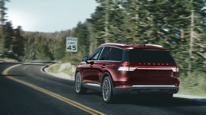 A 2024 Lincoln Aviator® SUV is being driven on a winding mountain road | Beck Lincoln in Palatka FL
