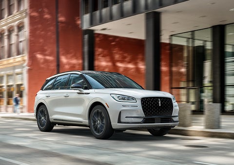 The 2024 Lincoln Corsair® SUV with the Jet Appearance Package and a Pristine White exterior is parked on a city street. | Beck Lincoln in Palatka FL