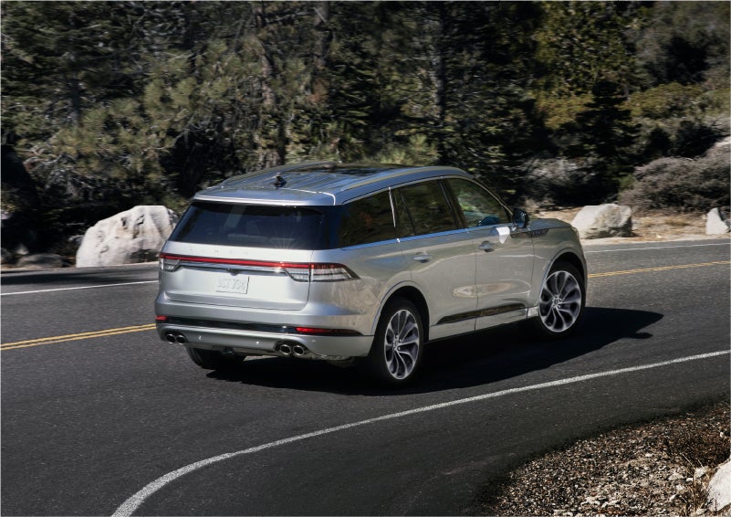 A 2023 Lincoln Aviator® Grand Touring model is shown being driven on a tight turn of a mountain road | Beck Lincoln in Palatka FL